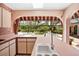 Kitchen with light pink countertops and a view of the backyard pool through an archway at 6049 Patricia Pl, Weeki Wachee, FL 34607