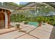 Inviting screened-in pool area with lush landscaping and covered lounge space, perfect for relaxation at 6049 Patricia Pl, Weeki Wachee, FL 34607