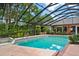 Backyard pool and spa in screened enclosure with tile border and green landscaping at 6049 Patricia Pl, Weeki Wachee, FL 34607