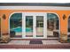 French doors offer convenient access to the screened-in pool area with nice landscaping and ample light at 6049 Patricia Pl, Weeki Wachee, FL 34607