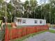 Gray manufactured home with red picket fence at 11876 Keylime Dr, New Port Richey, FL 34654