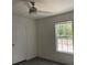 Bright bedroom with ceiling fan, window, and grey carpet at 11876 Keylime Dr, New Port Richey, FL 34654