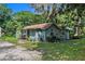 Side view of the cottage, showcasing its light blue exterior and garden at 1026 Roosevelt Ave, Spring Hill, FL 34604