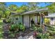 Covered patio area adjacent to the house with lush landscaping at 1026 Roosevelt Ave, Spring Hill, FL 34604