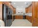 View of kitchen with dark wood cabinets, granite countertops, and black appliances at 1383 Dartford Dr, Tarpon Springs, FL 34688