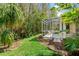Screened patio with lush landscaping and wood chips at 1383 Dartford Dr, Tarpon Springs, FL 34688