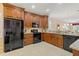 Spacious kitchen with dark wood cabinets, granite countertops, and black appliances at 1383 Dartford Dr, Tarpon Springs, FL 34688