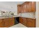 Kitchen with dark wood cabinets, granite countertops, and black appliances at 1383 Dartford Dr, Tarpon Springs, FL 34688