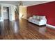 Open concept living room featuring wood floors, red accent wall and staircase at 1873 Mazo Mnr # T5, Lutz, FL 33558