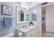 Bright bathroom featuring a vanity with sink, a large mirror, and a doorway entrance at 770 Island Way # N302, Clearwater, FL 33767