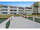 Dock leading to a condo building with picturesque waterfront views, blending modern living with natural beauty at 770 Island Way # N302, Clearwater, FL 33767