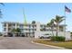 Well-maintained condo complex with white exterior, blue accents, and ample parking at 770 Island Way # N302, Clearwater, FL 33767