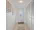 Hallway features decorative wall art, neutral tile flooring, and closet space at 770 Island Way # N302, Clearwater, FL 33767