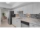 Modern kitchen with white cabinets, granite countertops, and stainless steel appliances at 770 Island Way # N302, Clearwater, FL 33767