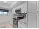 Modern kitchen with white cabinets, granite countertops, and stainless steel appliances at 770 Island Way # N302, Clearwater, FL 33767