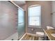 Modern bathroom with a glass-enclosed shower, tiled walls, a large window and sleek fixtures at 13753 Judy Ave, Hudson, FL 34667
