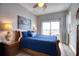 Cozy bedroom with a queen-sized bed, classic wood furniture, and a sliding glass door to a private balcony at 13753 Judy Ave, Hudson, FL 34667