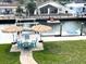 Waterfront backyard featuring a dock, patio set with umbrellas, and a hammock on a sunny day at 13753 Judy Ave, Hudson, FL 34667