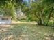 Large backyard with mature trees and wooden fence at 4252 Courier Ln, Holiday, FL 34691