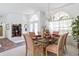 Elegant dining room features a glass table set for six with large arched windows and a chandelier at 21312 Preservation Dr, Land O Lakes, FL 34638