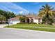 Beautiful single-story home featuring a manicured lawn, palm trees, and a three-car garage at 21312 Preservation Dr, Land O Lakes, FL 34638