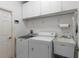 Functional laundry room with washer, dryer, utility sink, and ample storage cabinets at 21312 Preservation Dr, Land O Lakes, FL 34638