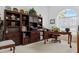 Home office featuring a built-in bookcase, a wooden desk, and natural light from a large window at 21312 Preservation Dr, Land O Lakes, FL 34638