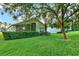 Landscaped backyard with lush lawn and mature trees at 3211 Banyan Hill Ln, Land O Lakes, FL 34639