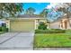 Charming house with a green exterior, two-car garage, and well-maintained lawn at 3211 Banyan Hill Ln, Land O Lakes, FL 34639