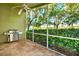 Relaxing screened porch with tiled floor and built-in grill at 3211 Banyan Hill Ln, Land O Lakes, FL 34639