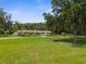 Ranch style home with a large grassy yard and a porch swing at 19351 Yontz Rd, Brooksville, FL 34601