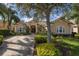 Stunning single-story home featuring a tile roof, double-door entryway, and lush landscaping at 1453 El Pardo Dr, Trinity, FL 34655