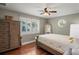 Cozy bedroom with wood floors, a ceiling fan, and a large window at 3154 Brigantine Ct, New Port Richey, FL 34652