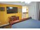 Main bedroom with a king-size bed, a large TV, and views of the kitchen at 2077 Wetland Pt # 1202, Lutz, FL 33558