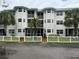 Two-story condo building with white exterior, screened balconies, and a white picket fence at 2077 Wetland Pt # 1202, Lutz, FL 33558