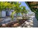 Tranquil backyard featuring lush landscaping, a cozy bench, and a serene waterfront view with tropical accents at 6629 Harbor Dr, Hudson, FL 34667