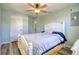 Well-lit bedroom with a white bed frame, ceiling fan, and light hardwood floors at 6629 Harbor Dr, Hudson, FL 34667