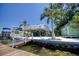 Waterfront home featuring dock access, mature palm trees and a bright, white exterior at 6629 Harbor Dr, Hudson, FL 34667
