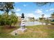 Charming pond with lighthouse sculpture and residential homes at 6020 Wilds Dr # 4B, New Port Richey, FL 34653