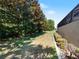 Landscaped side yard with mature trees and shrubs at 5378 Legend Hills Ln, Spring Hill, FL 34609
