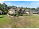 Tan one-story house with lush landscaping and a curved driveway at 5378 Legend Hills Ln, Spring Hill, FL 34609