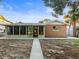 Rear view of house, showcasing sunroom and walkway at 13912 Sommers Ave, Hudson, FL 34667