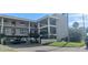 Three-story condo building with covered parking and tropical landscaping at 8210 Aquila St # 226, Port Richey, FL 34668