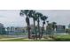 Well-maintained tennis courts with benches, surrounded by palm trees at 8210 Aquila St # 226, Port Richey, FL 34668