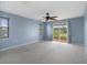 Spacious bedroom with carpet flooring, ceiling fan, and sliding glass door to balcony at 3480 Croaker Dr, Hernando Beach, FL 34607