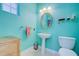 Small powder room with pedestal sink and toilet, painted in a teal color at 7352 Gulf Way, Hudson, FL 34667