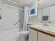 Clean bathroom with marble-tiled bathtub, shower, and vanity with wood cabinets at 5537 Sea Forest Dr # 307, New Port Richey, FL 34652