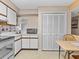 White kitchen cabinets, stone backsplash and an adjacent dining area at 5537 Sea Forest Dr # 307, New Port Richey, FL 34652