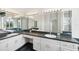 Double vanity bathroom with dark countertops and marble-look flooring at 329 Sunset Way, Palm Harbor, FL 34683