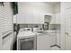 Laundry room with washer, dryer, and white cabinets at 329 Sunset Way, Palm Harbor, FL 34683